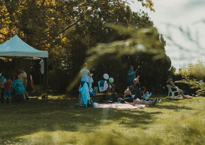 families sit on blankets spread out in the clearing and have a nice time